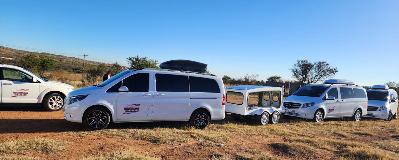 the image shows three vehicles belonging to Ithemba Elitjha Funeral services. The main vehicle in the picture is a white Mercedes Benz V-class passenger car branded with Ithemba Elitjha branding and behind it, there's a coffin carriage