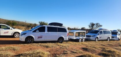 the image shows three vehicles belonging to Ithemba Elitjha Funeral services. The main vehicle in the picture is a white Mercedes Benz V-class passenger car branded with Ithemba Elitjha branding and behind it, there's a coffin carriage